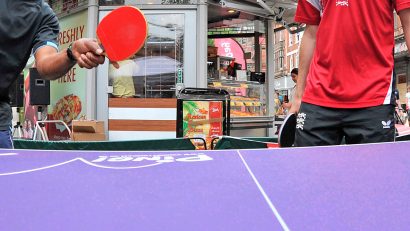 chicos jugando al ping pong en la calle