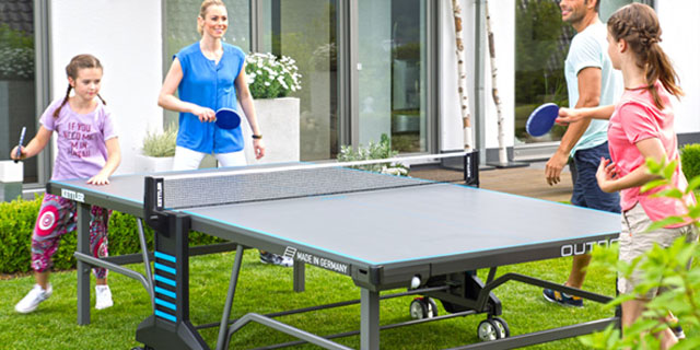 familia jugando al ping pong en el jardín